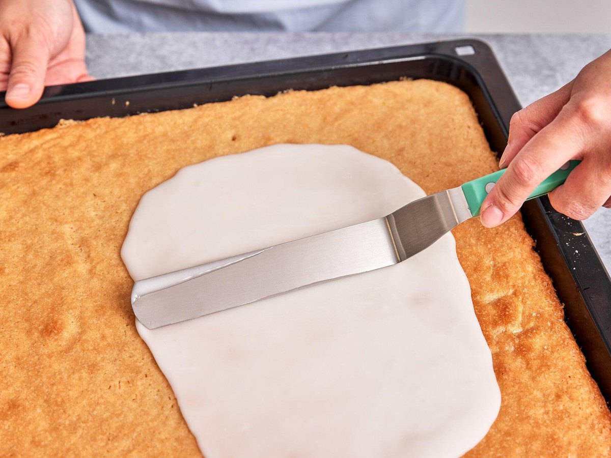Guss wird auf Kuchen verteilt